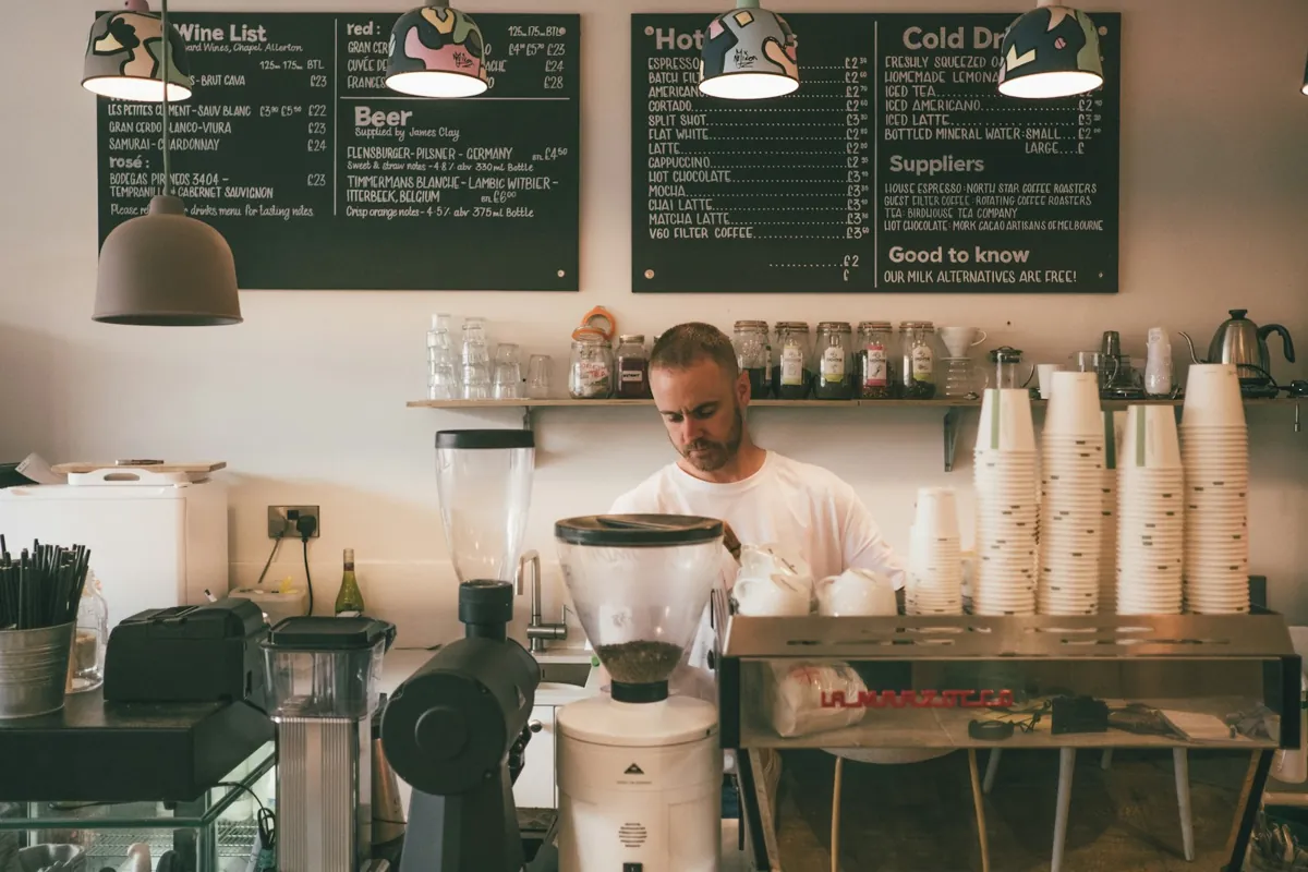 A café worker preparing drinks behind the counter