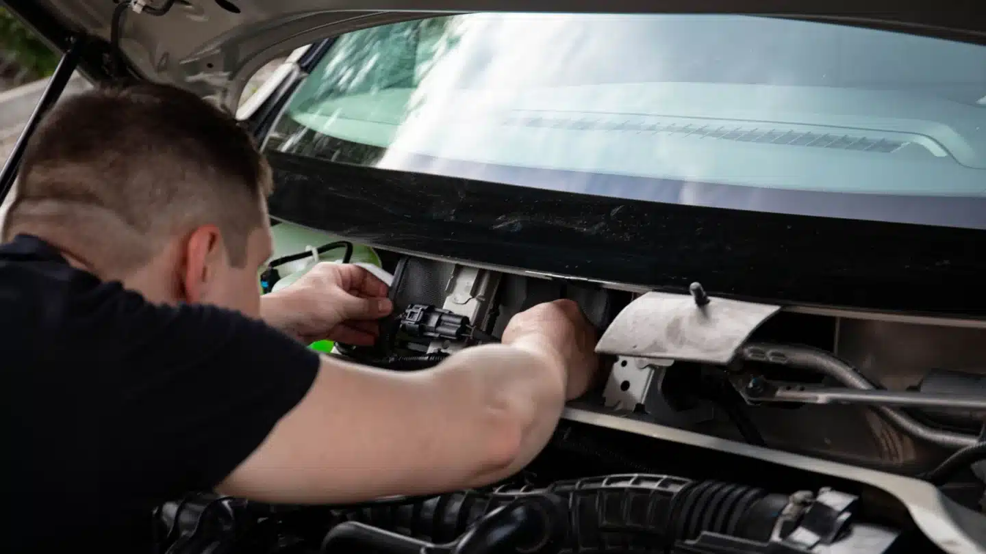 Automotive Aftermarket PPC Agency: mechanic inspecting a vehicle engine bay