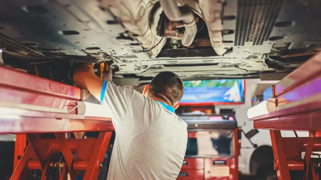 Collision Repair Digital Marketing Agency: technician working under a lifted vehicle