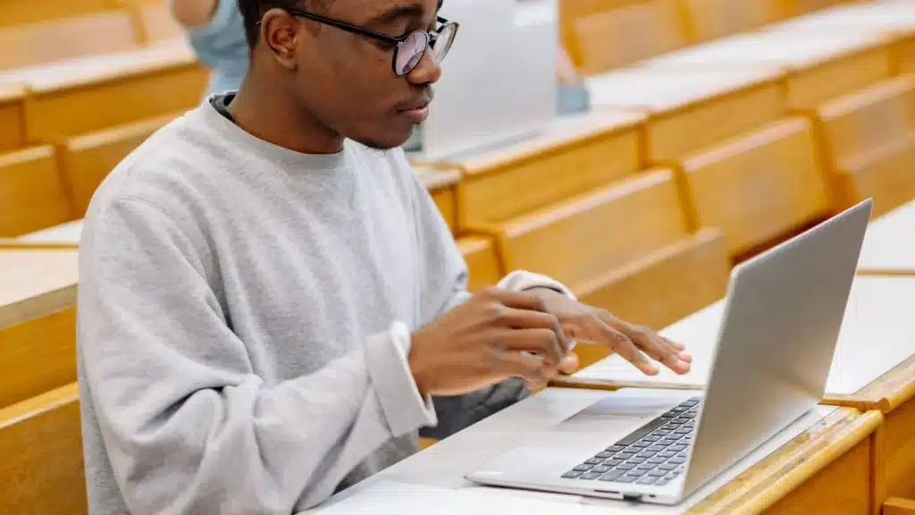 Career College and Trade School PPC Agency Photo A Career College and Trade School Google Ads Agency: student using a laptop in a modern classroom
