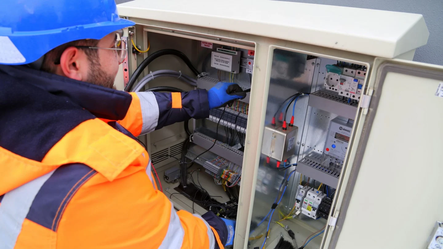 Electrical Contractors PPC Agency Hero Electrical Contractors PPC Agency: electrician inspecting an outdoor fuse box
